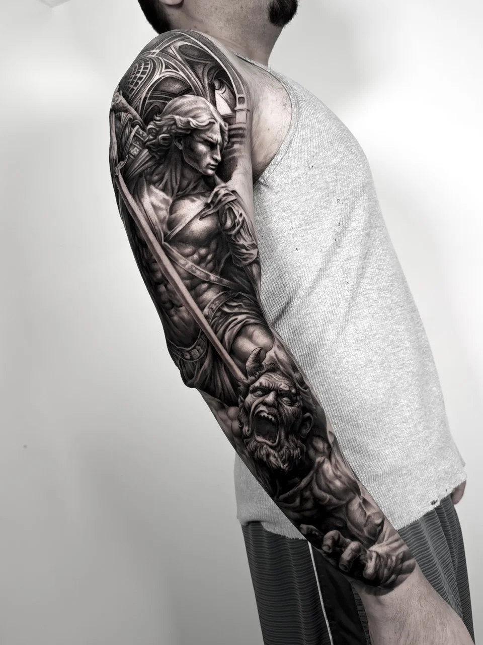 Black & Gray Realism tattoo by Ivan Cavassana: angel, sword, helmeted warrior, armor