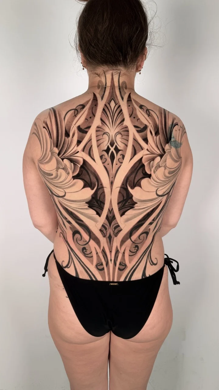 Blackwork tattoo by Gabriella Nova: floral patterns, ornamental shapes, scrollwork, vine-like elements