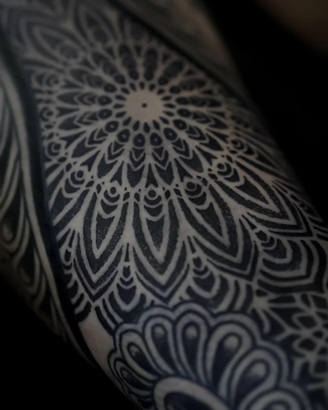 Blackwork tattoo by Oliver Kenton: mandala pattern, geometric shapes, flower motifs, geometric