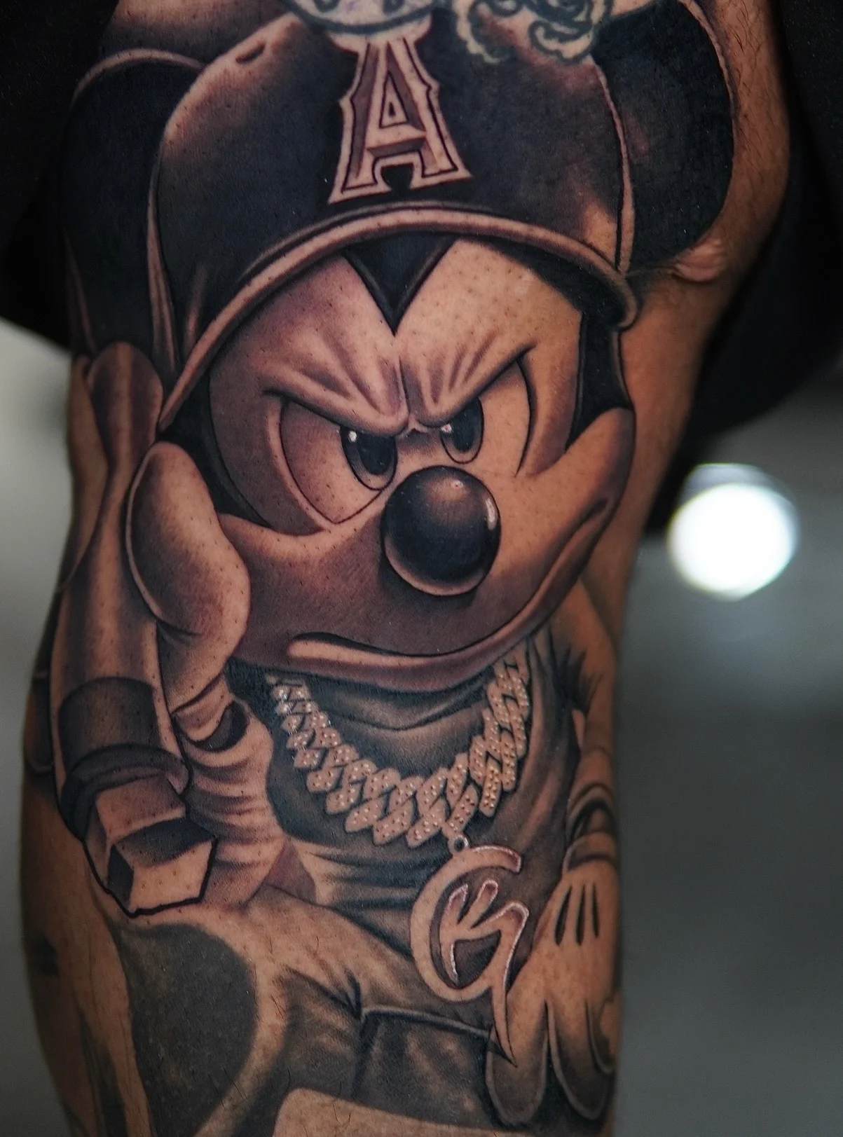 Black & Gray Realism tattoo by Daniel N Tattoo: mickey mouse, cap, chain necklace, pop culture