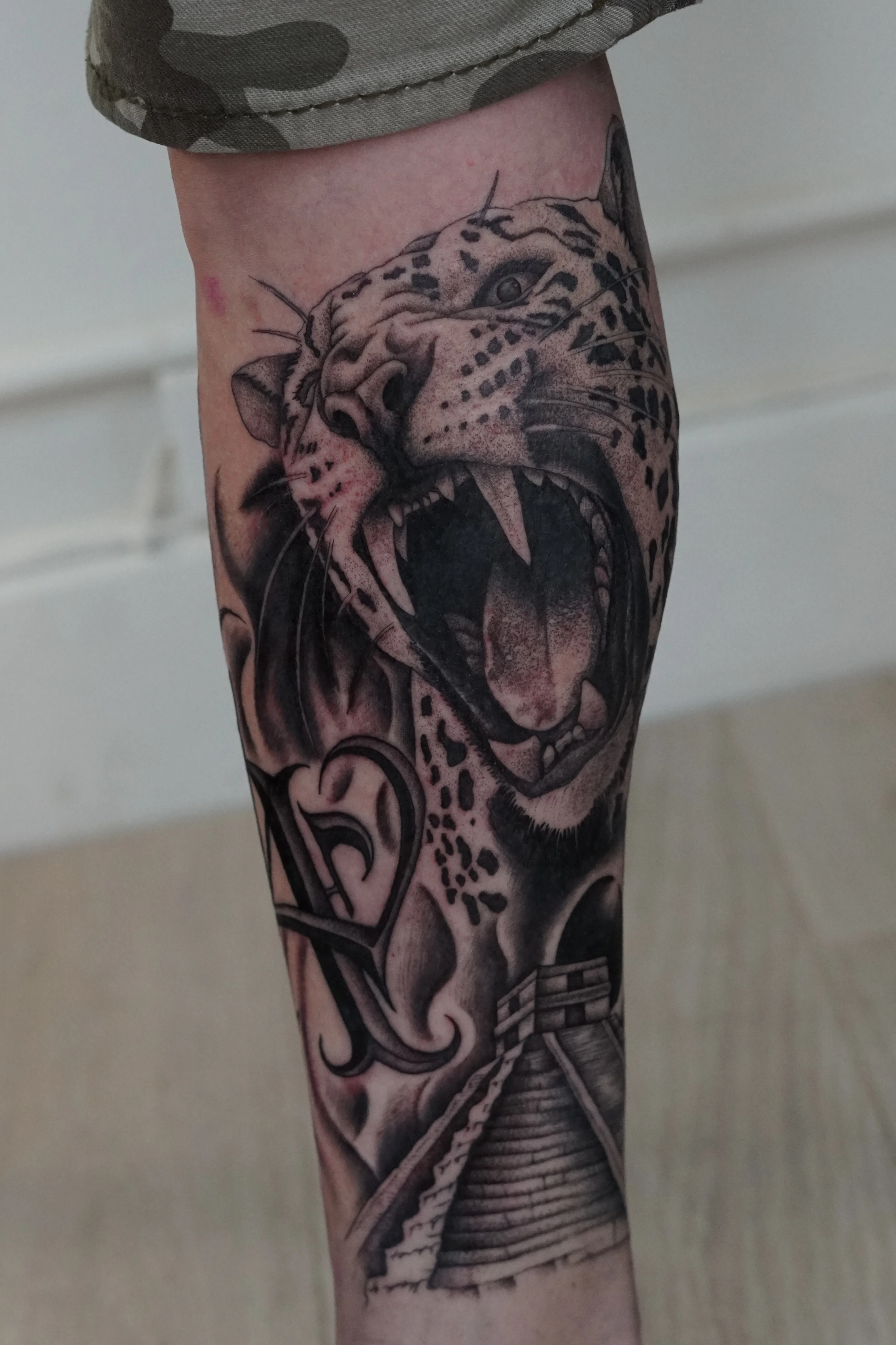 Black & Gray Realism tattoo by Kobe Virgen: jaguar, pyramid, ornamental letter, animal