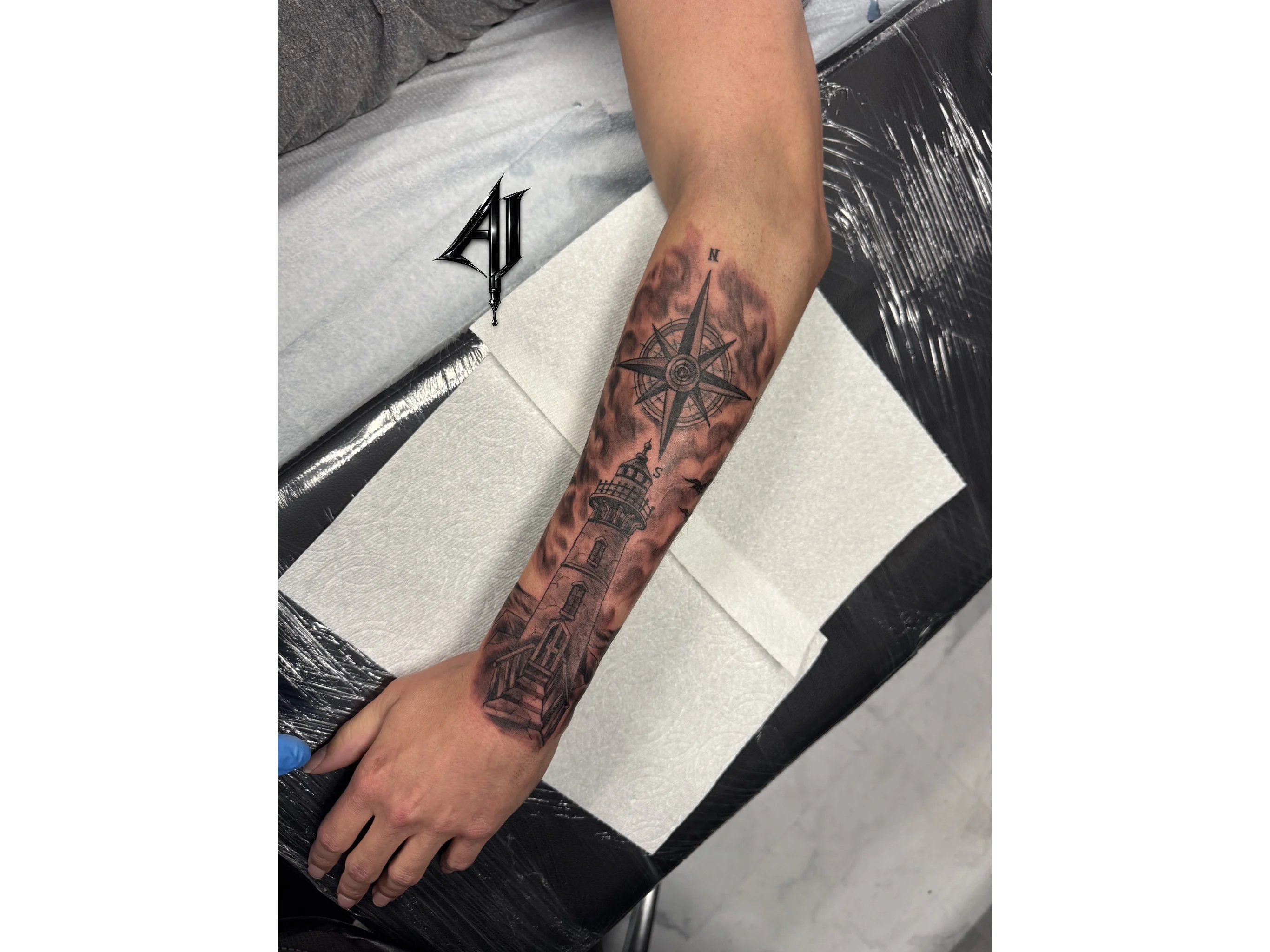 Black & Gray Realism tattoo by Andrei Ilin: lighthouse, compass rose, birds, clouds