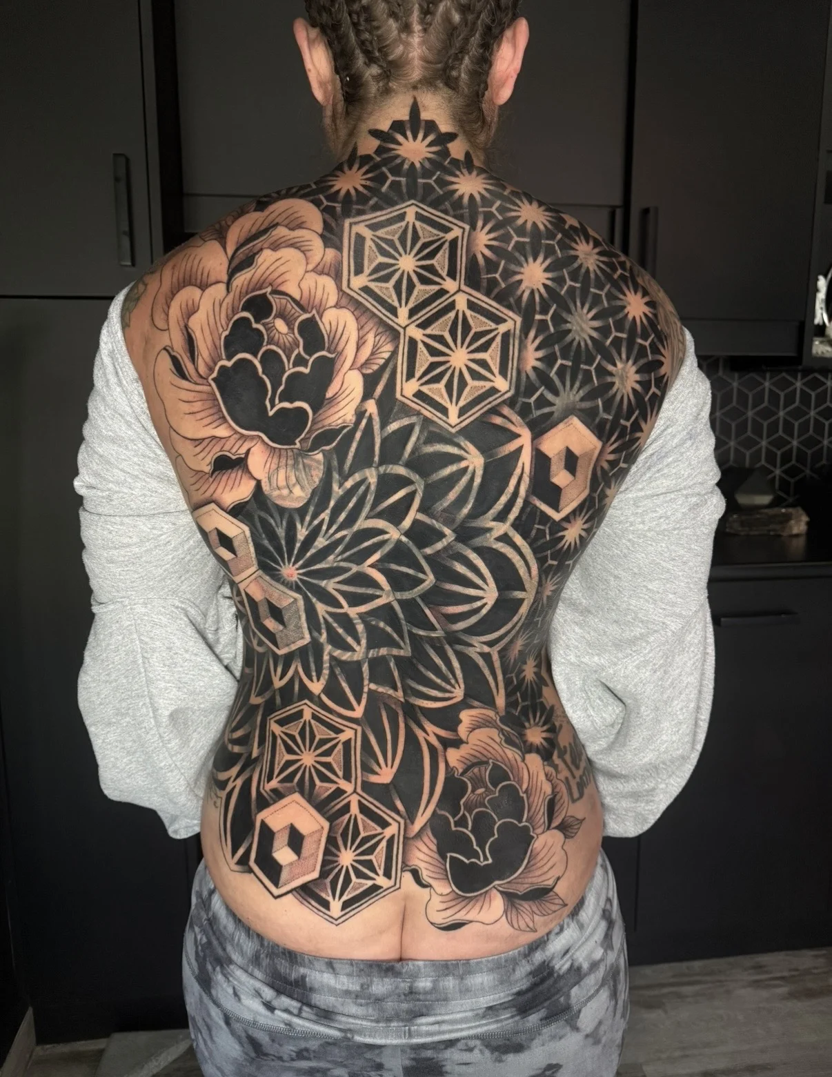 Blackwork tattoo by Crystal Alexandria: flowers, stars, hexagons, geometric shapes