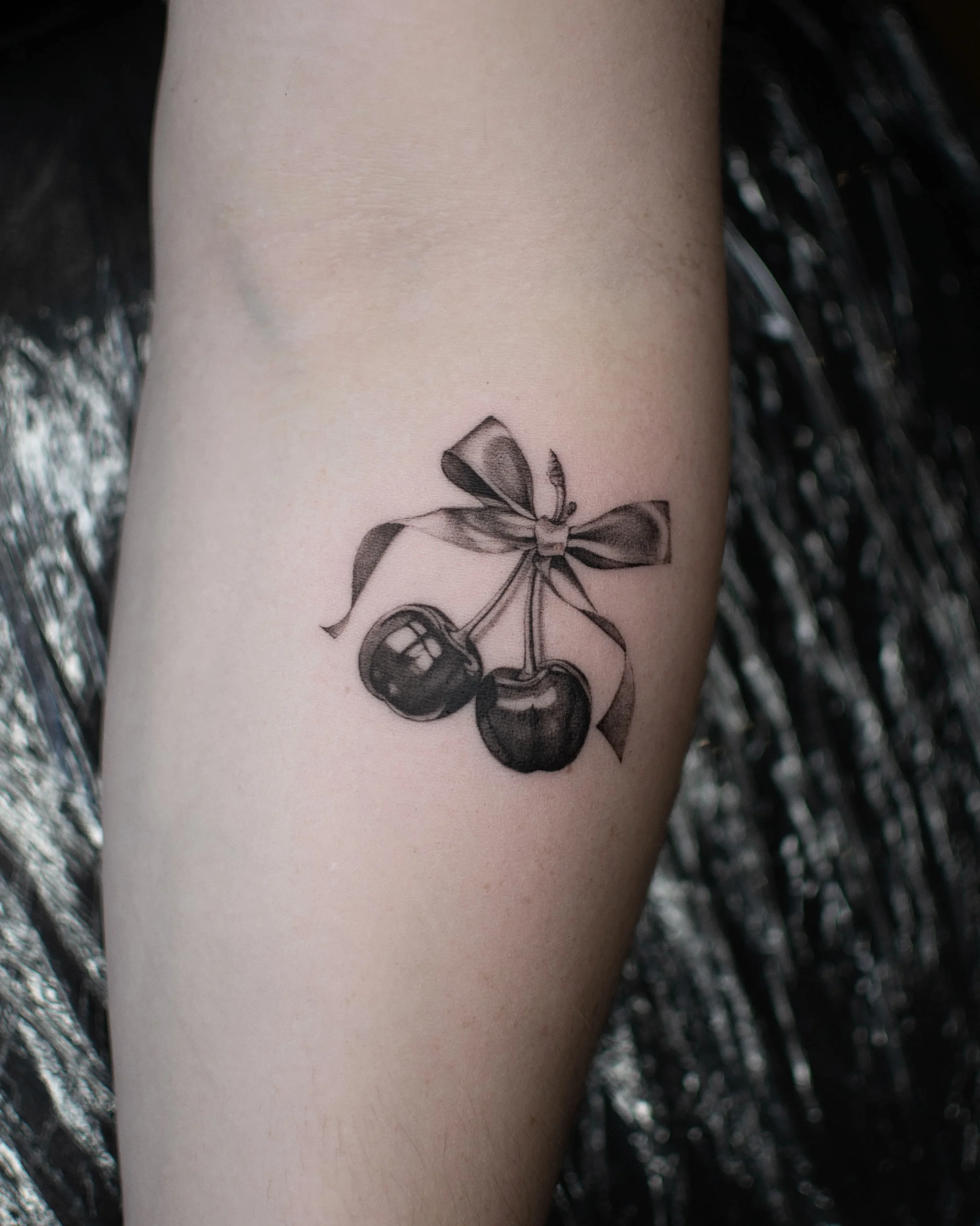 Black & Gray Realism tattoo by Vira.Ink: cherries, ribbon, bow, nature