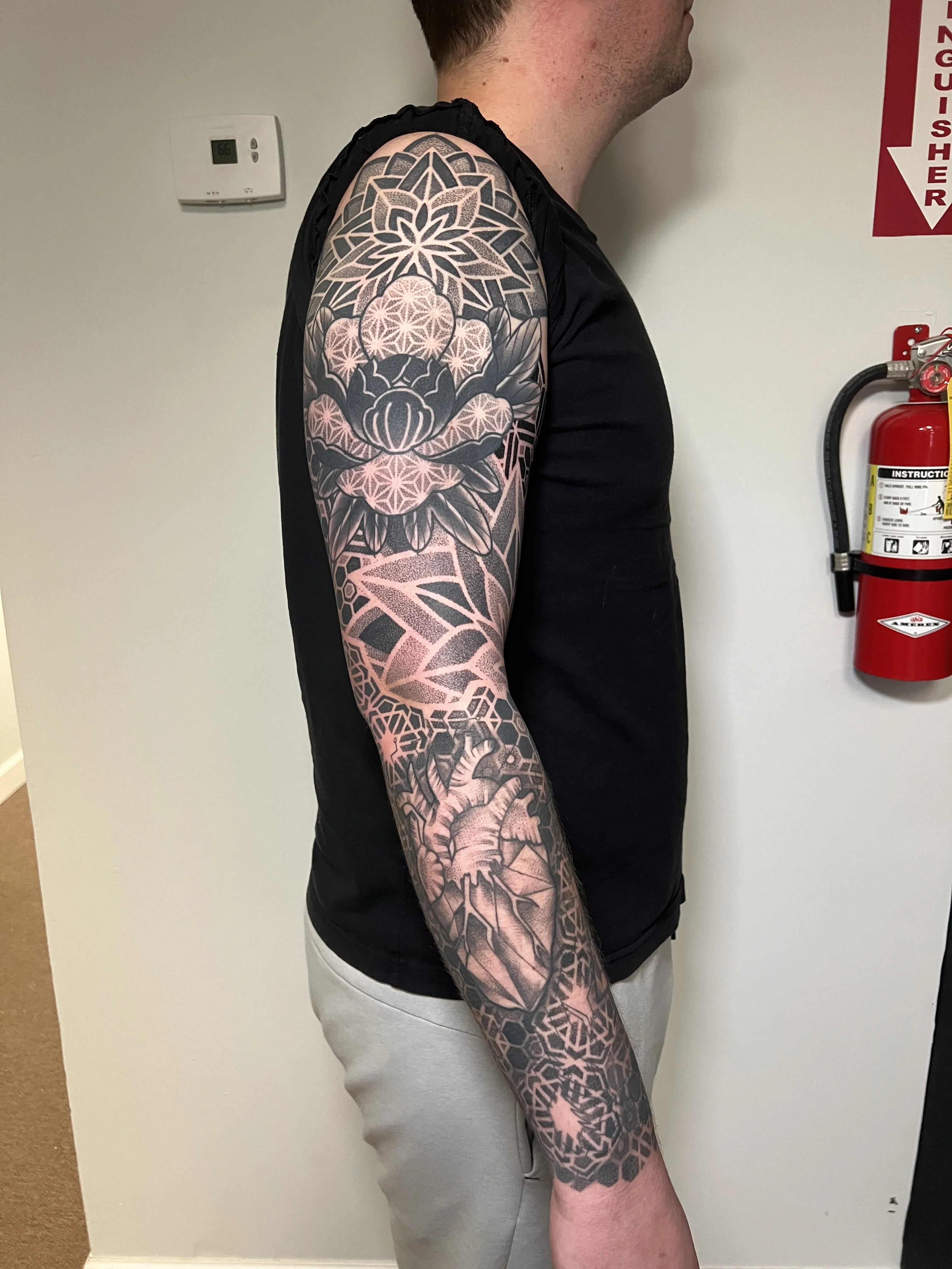 Blackwork tattoo by Erin Manning: geometric flower, lotus flower, anatomical heart, mandala