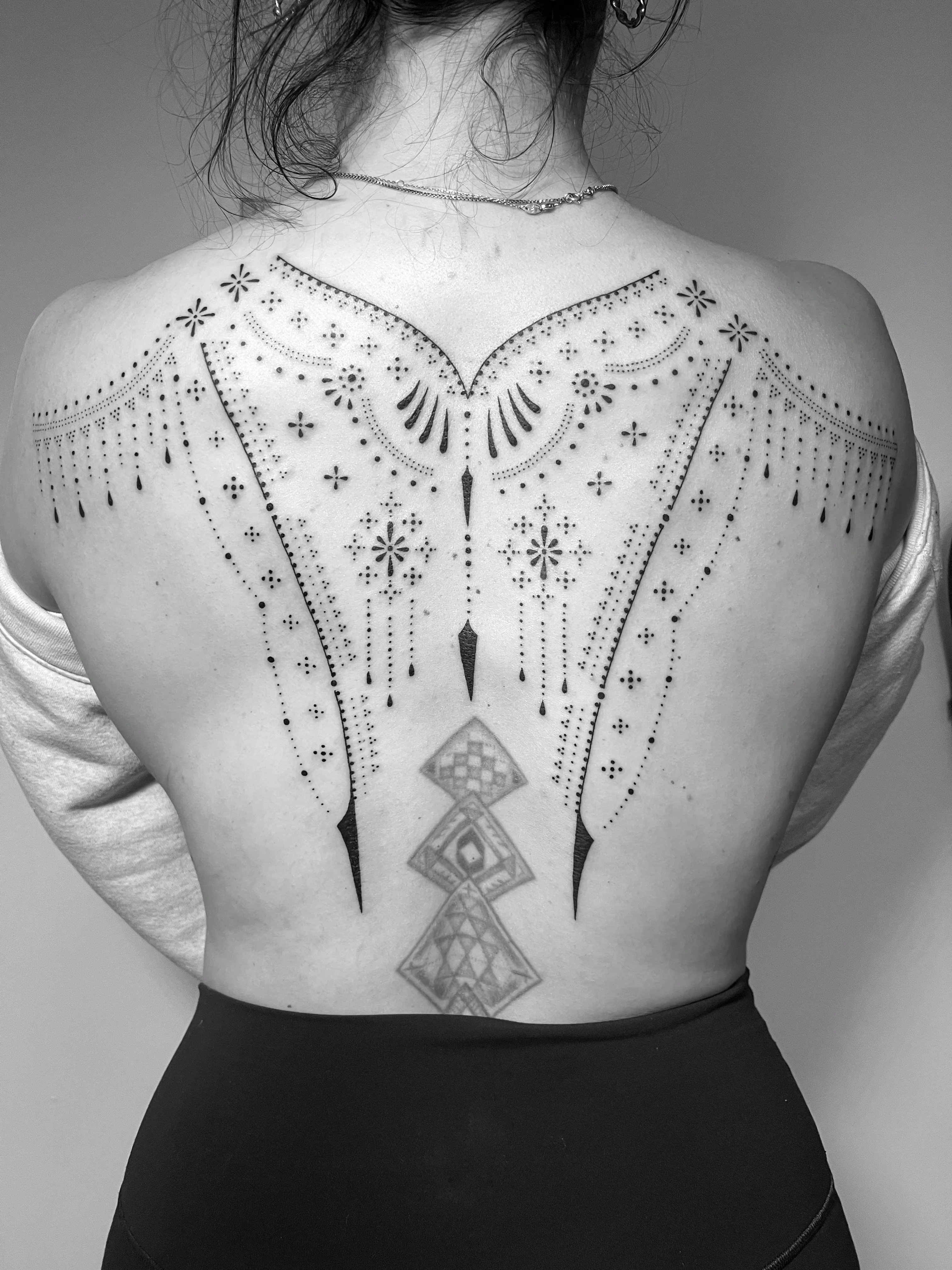 Fine Line tattoo by Erin Manning: dots, lines, geometric diamond shapes, floral patterns