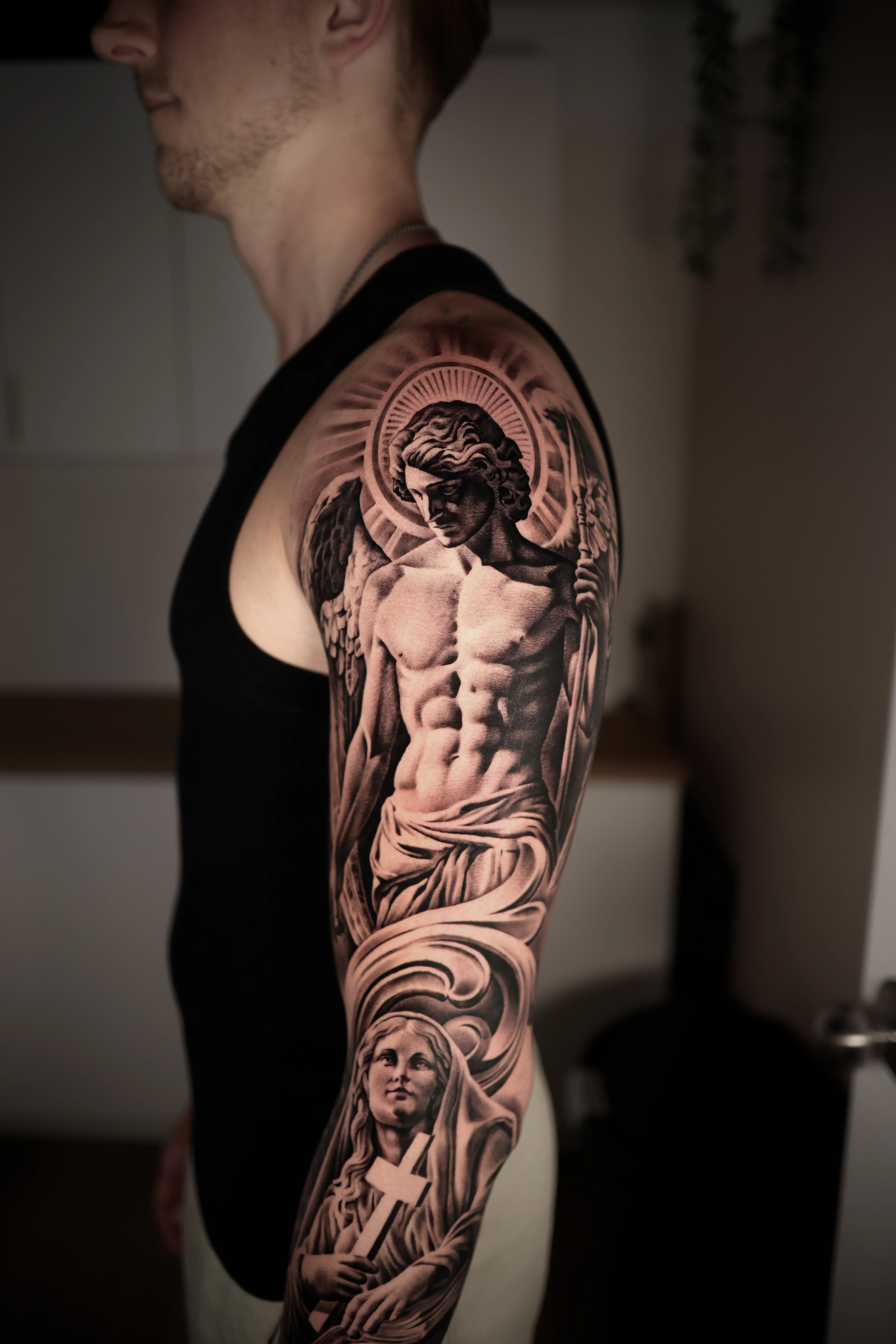 Black & Gray Realism tattoo by Ezra Currier: angel, halo, muscular male figure, wings