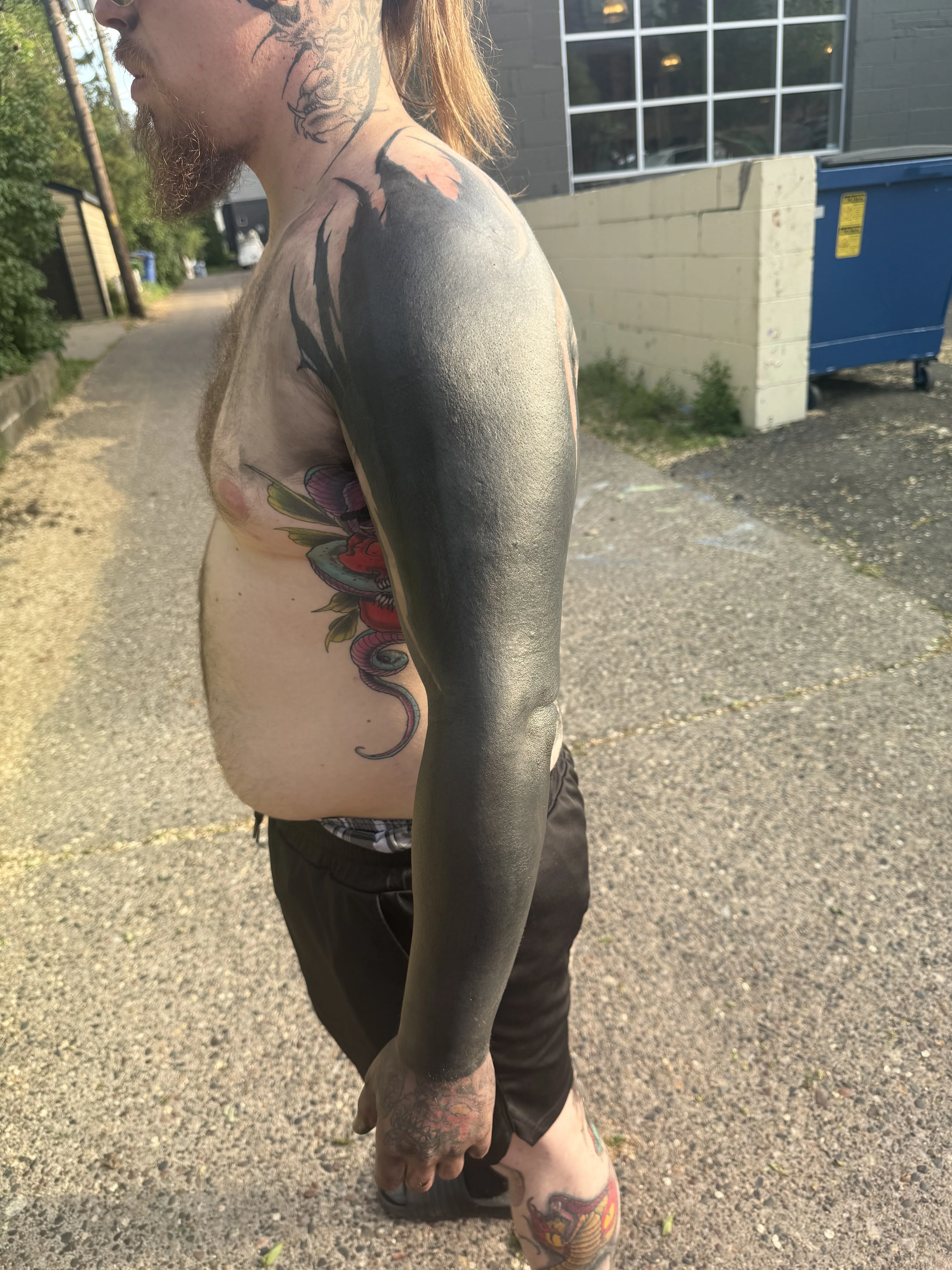 Blackwork tattoo by Donnie Chapman: black fill, flame edges, hand, forearm