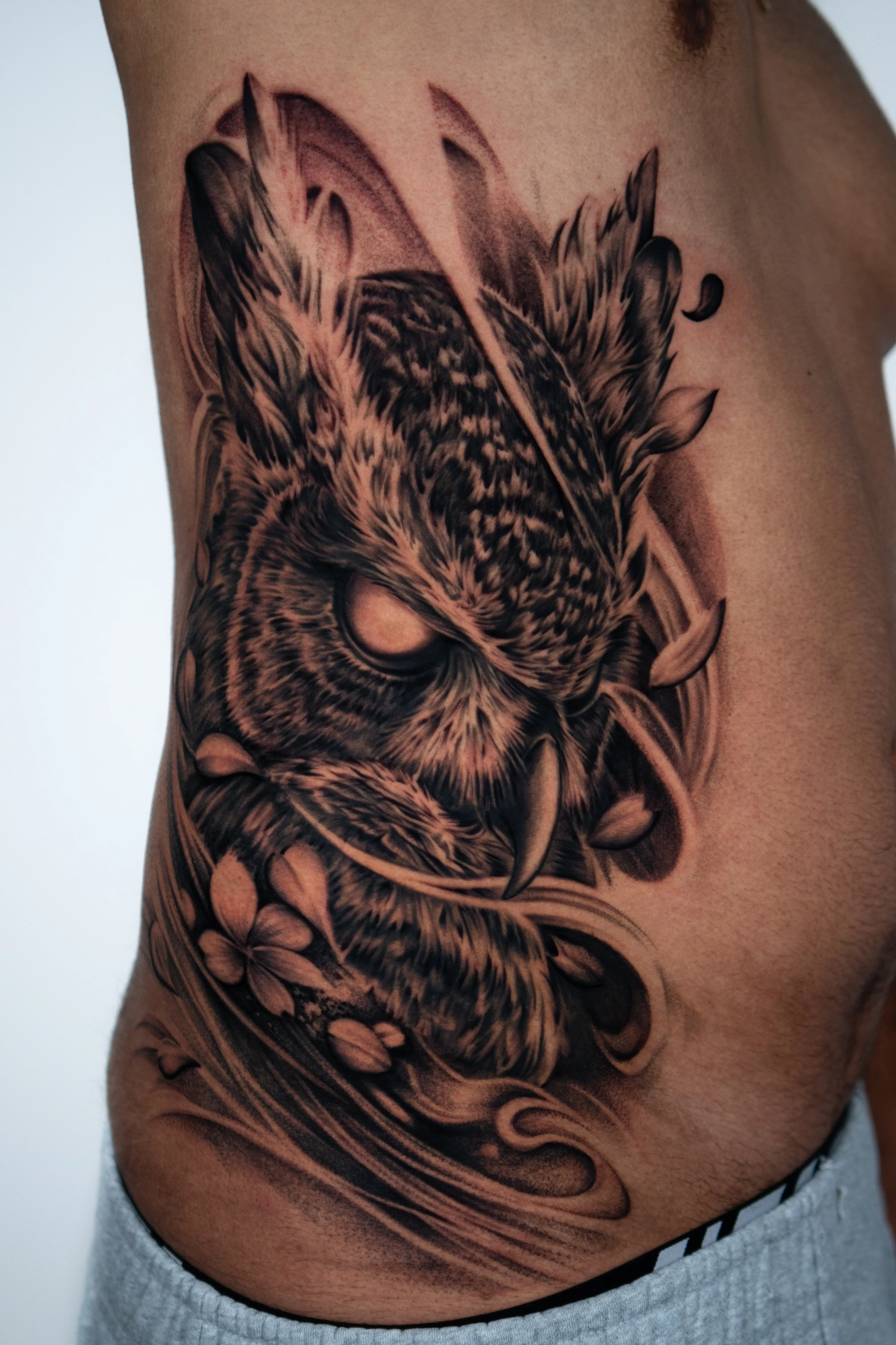 Black & Gray Realism tattoo by Do Santos: owl, feathers, flowers, animal
