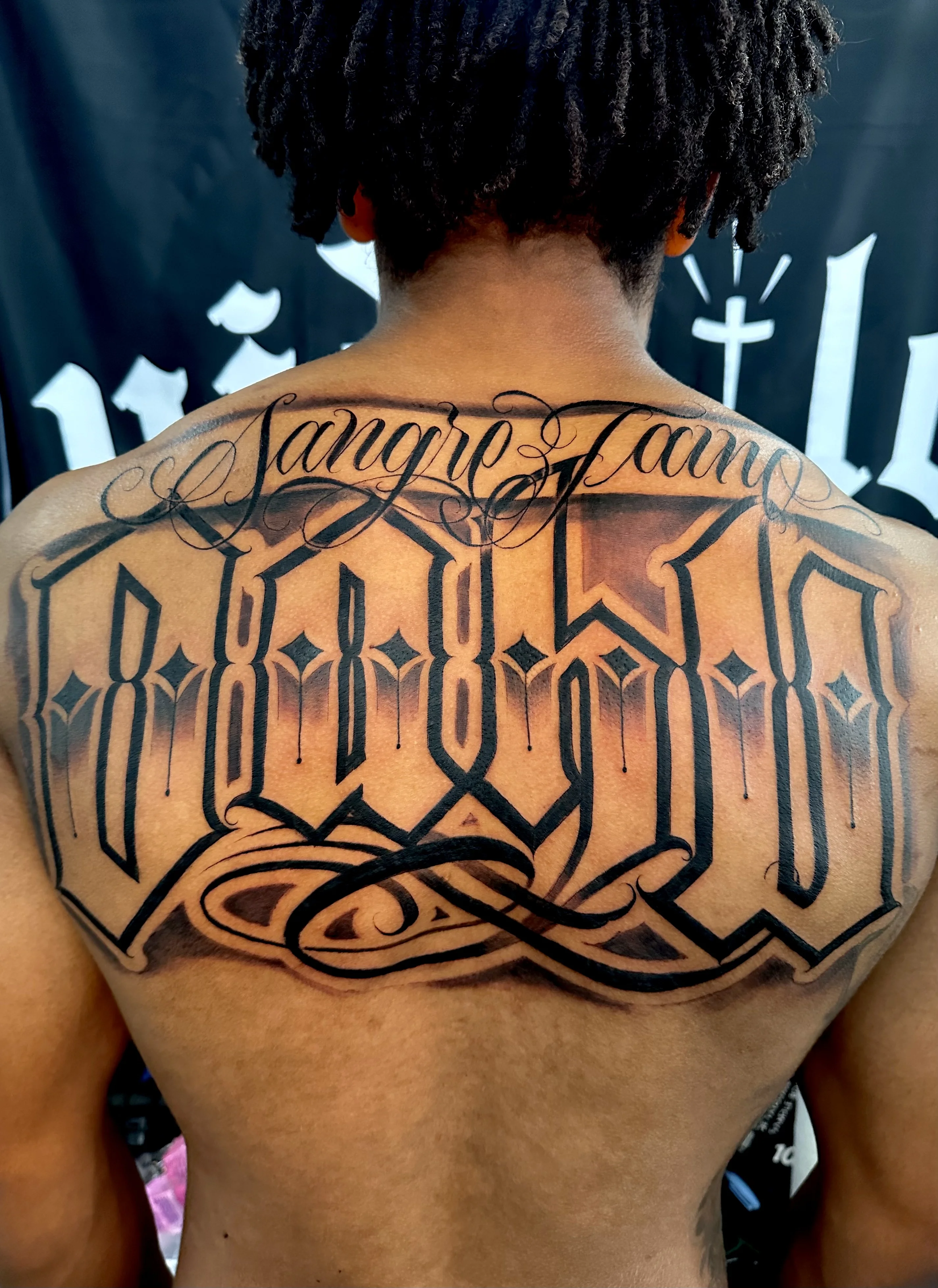 Blackwork tattoo by Danny Romeo Orellana Tat2one: script lettering, ornamental swirls, lettering, ornamental