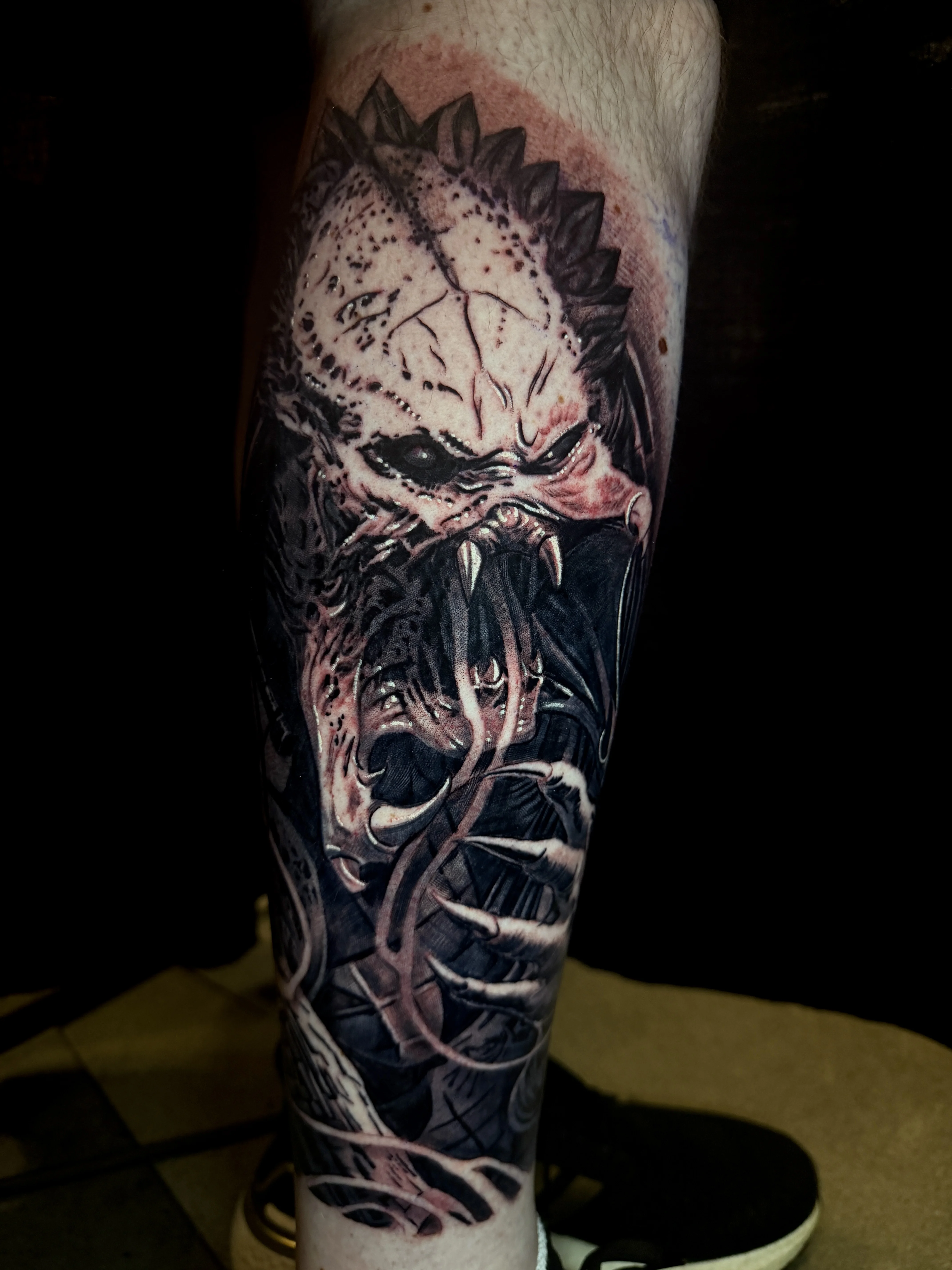 Black & Gray Realism tattoo by Danny Romeo Orellana Tat2one: predator alien, claws, open mouth, sharp teeth