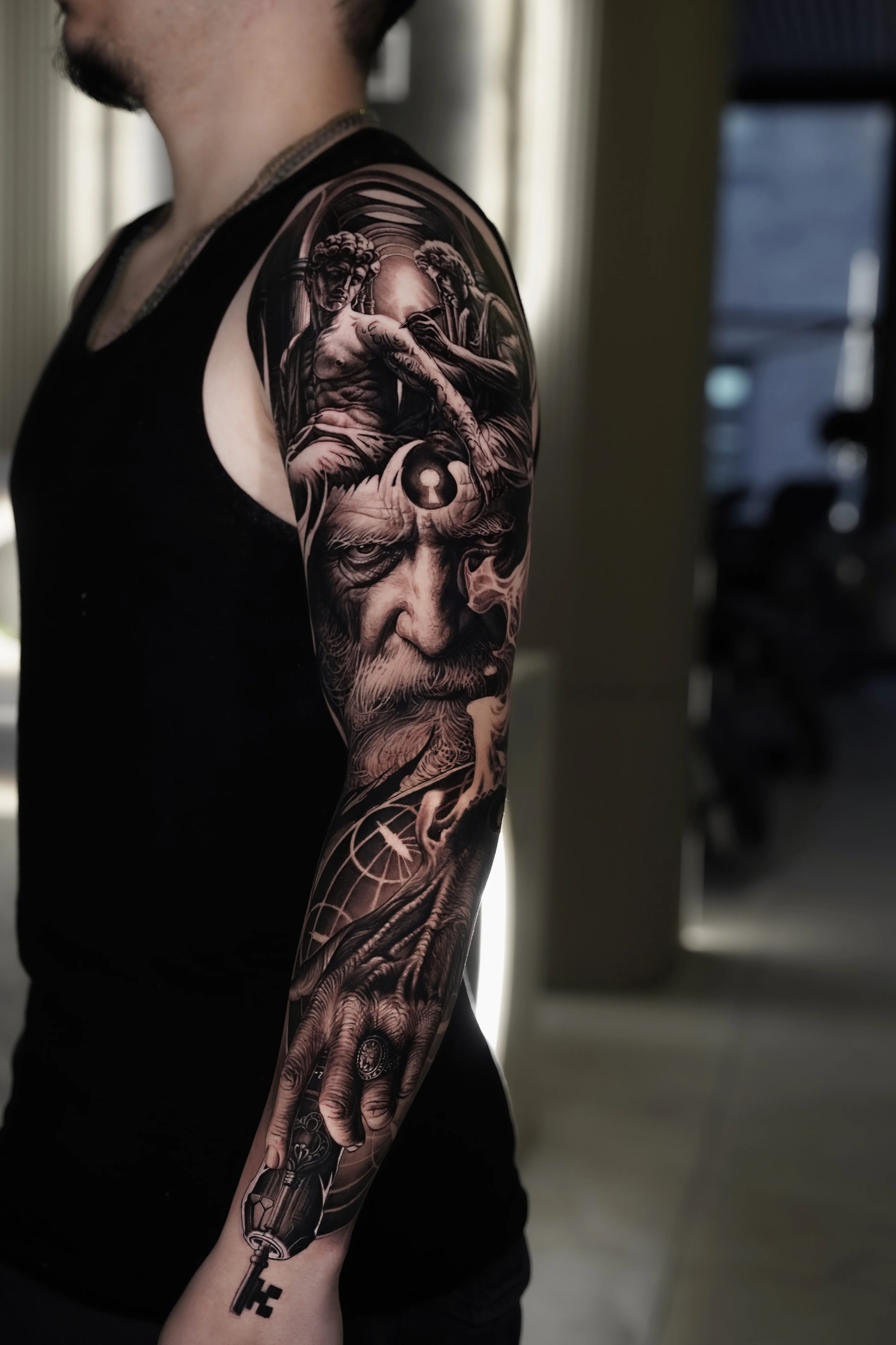 Mythological Black & Grey Full Sleeve: old man face, keyhole, angel, figure with wings, crow or raven, hand holding key
