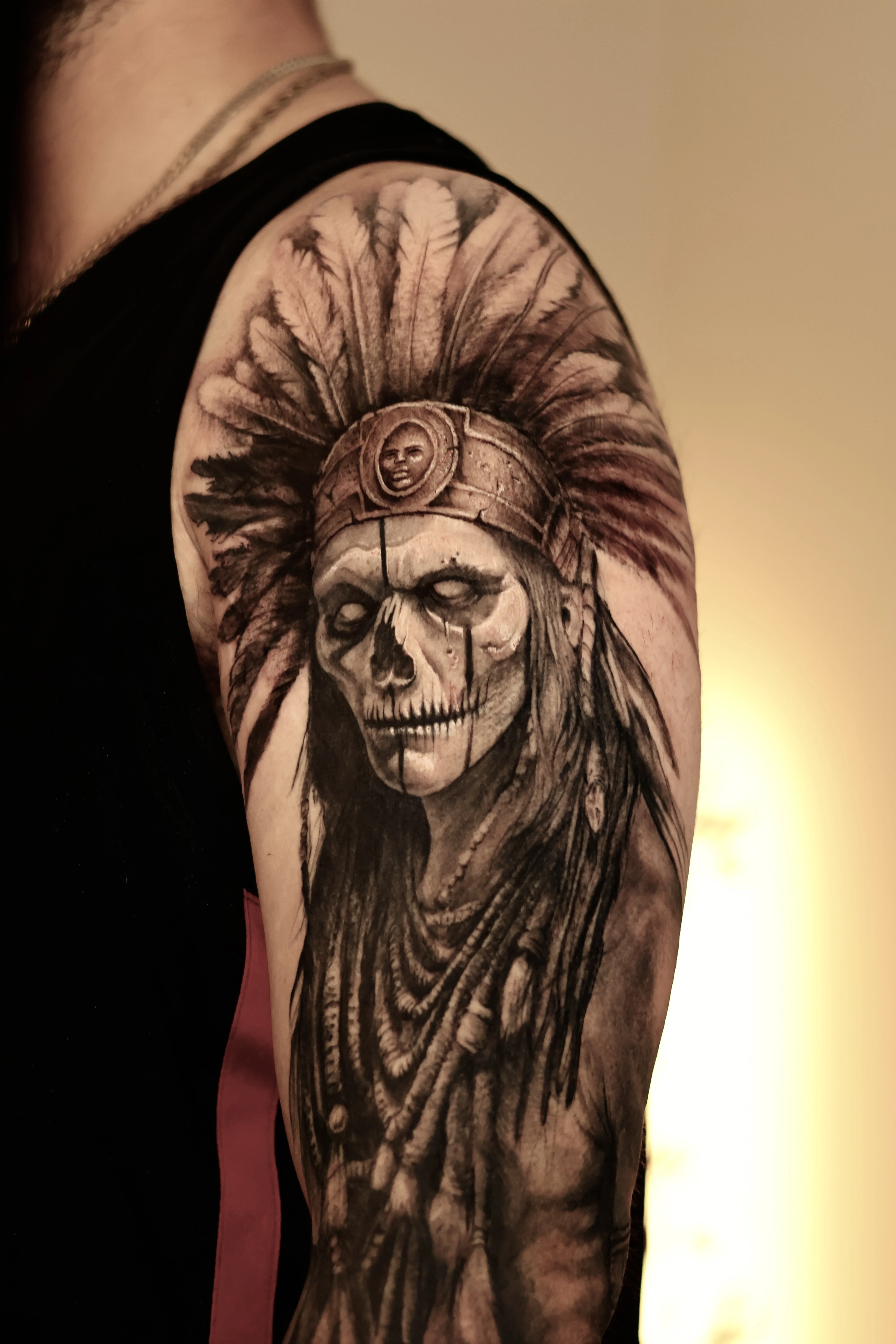 Black & Gray Realism tattoo by Emiliano Garrido: skull, native american headdress, feathers, face paint