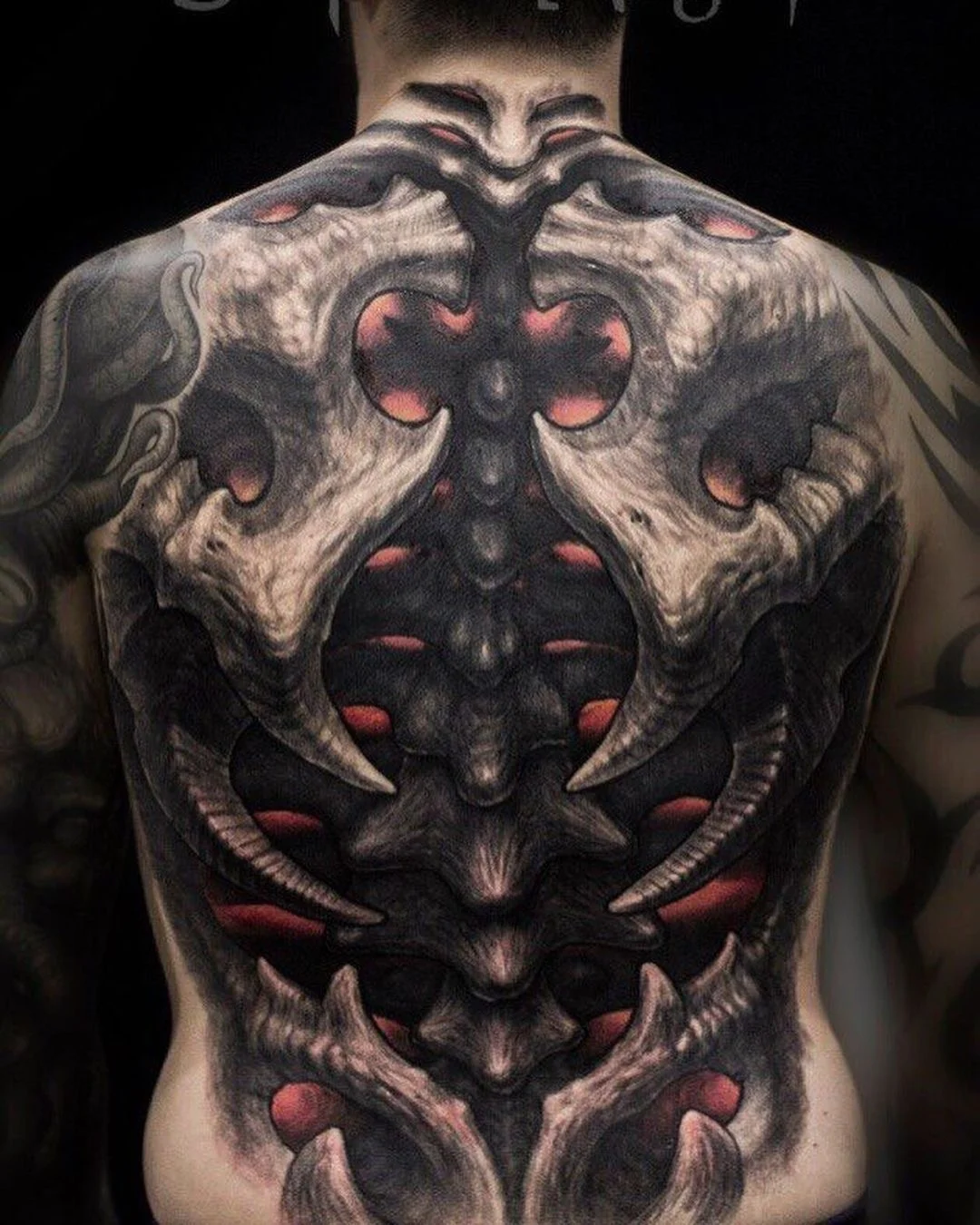 Biomechanical tattoo by Arte de José Manrique: skull, bone, ribs, horns