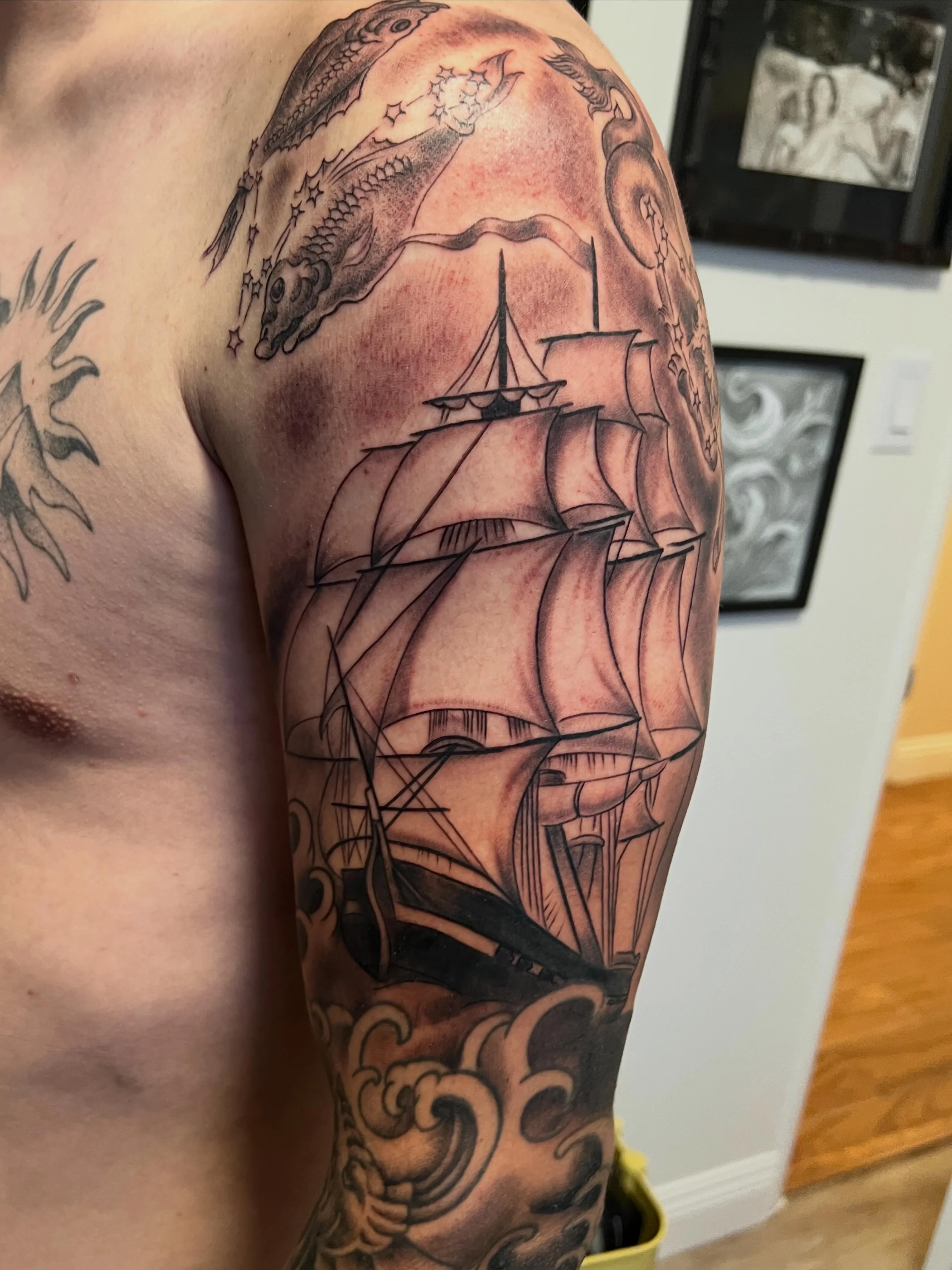 Black & Gray Realism tattoo by Justin Wilson: sailing ship, waves, constellation, stars