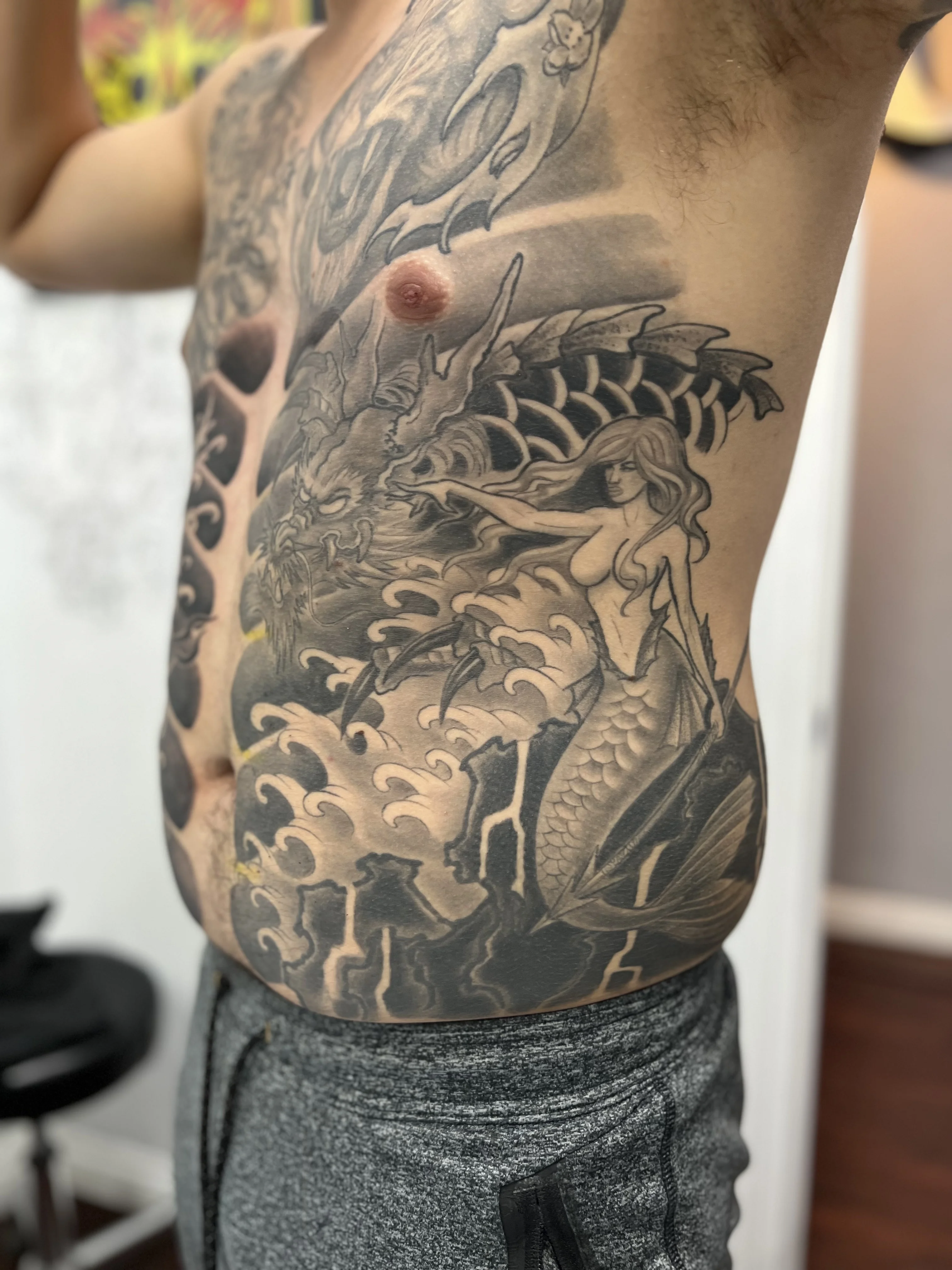 Black & Gray Realism tattoo by Justin Wilson: mermaid, dragon, waves, lightning