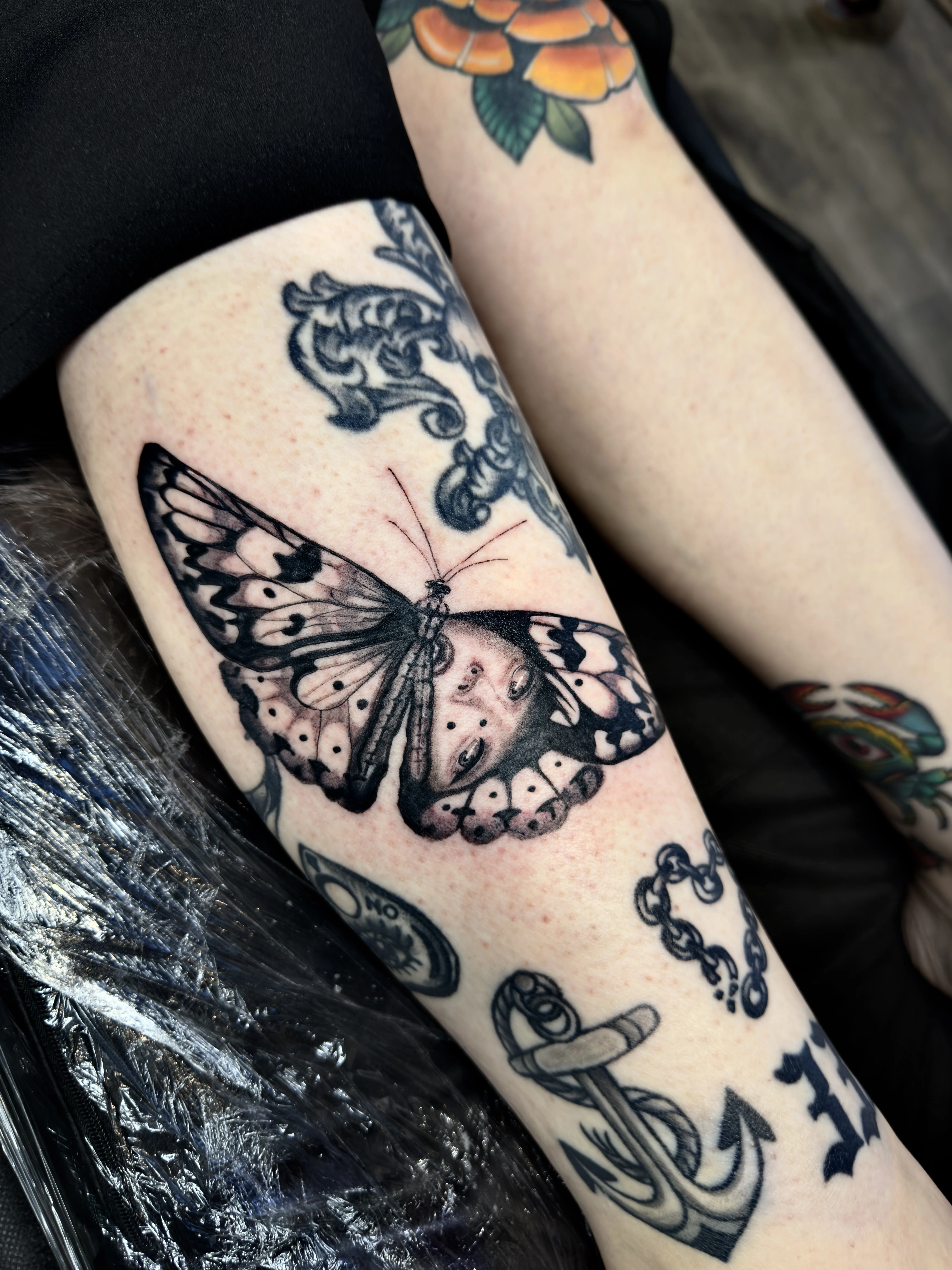 Black & Gray Realism tattoo by Churry Tattoos: butterfly, woman's face, anchor, floral ornament