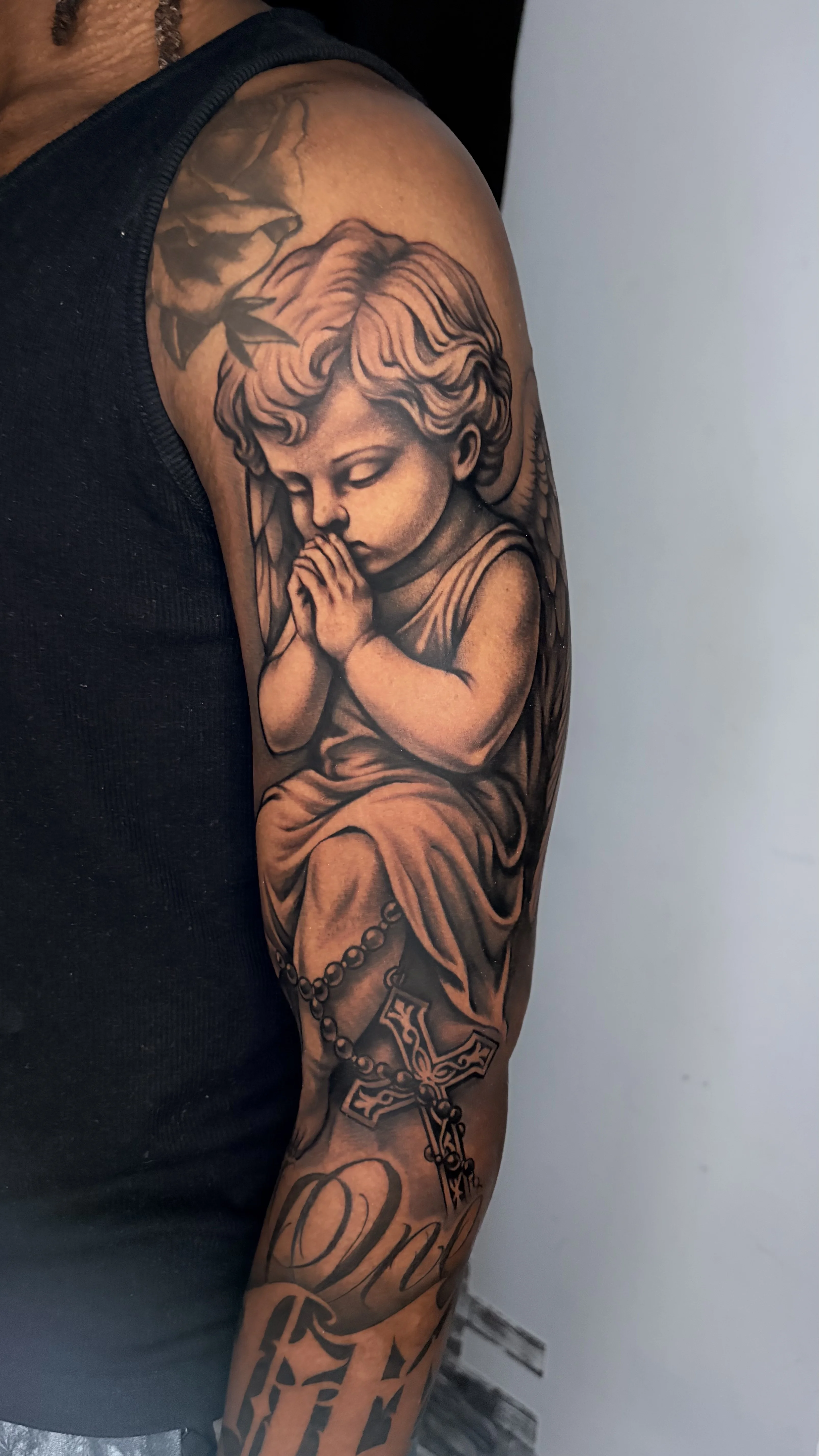 Black & Gray Realism tattoo by Kerasu: child angel, praying hands, cross, rosary beads