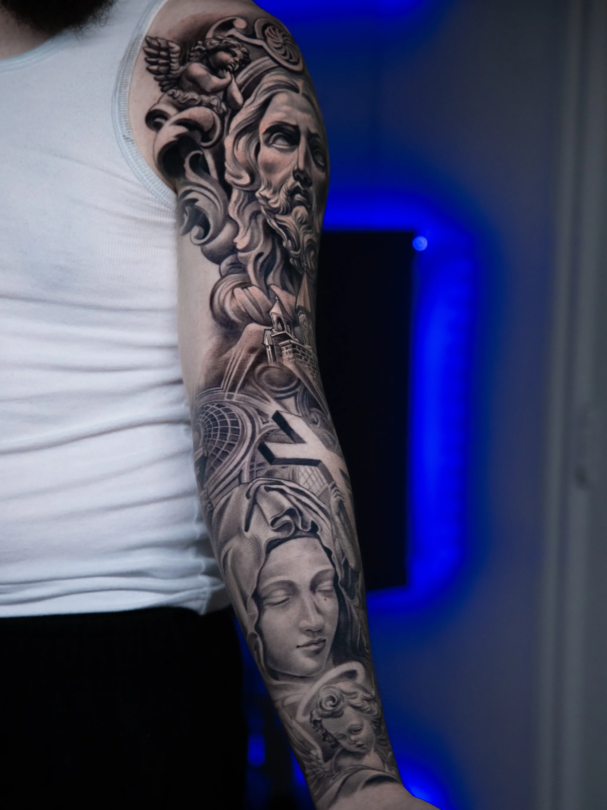 Black & Gray Realism tattoo by T-GRAN Ink: bearded man, angel, architectural elements, helmeted woman